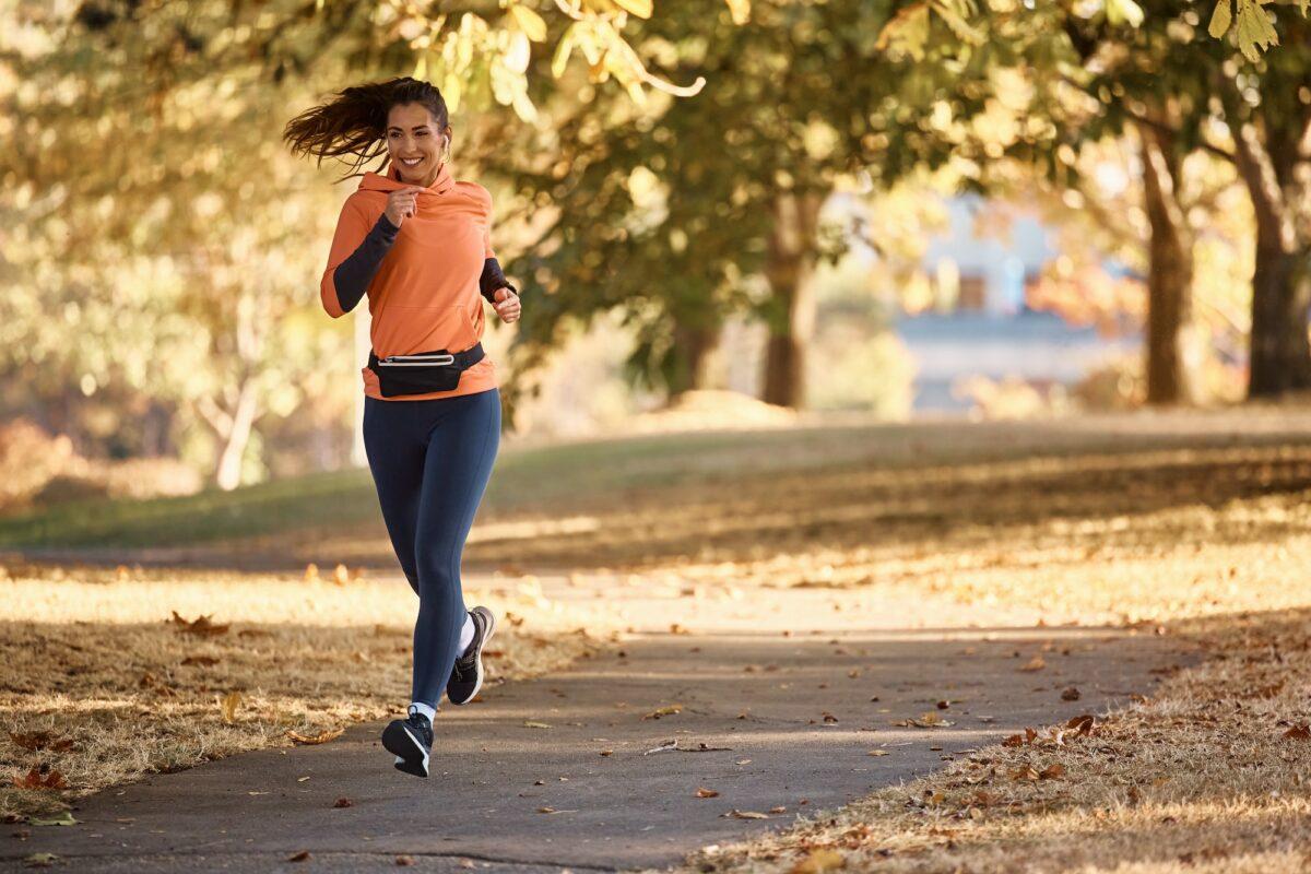 Sportliche Frau läuft in einem Park und setzt auf die Unterstützung von VitaKomplex Produkten für ihre Fitnessroutine.